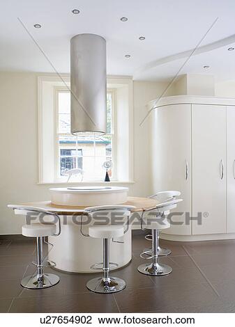 Cylindrical extractor above hob set in circular island unit with breakfast bar and white and chrome stools View Large Photo Image Stock Image - Cylindrical extractor above hob set in circular island unit with breakfast bar and white and chrome stools. Fotosearch