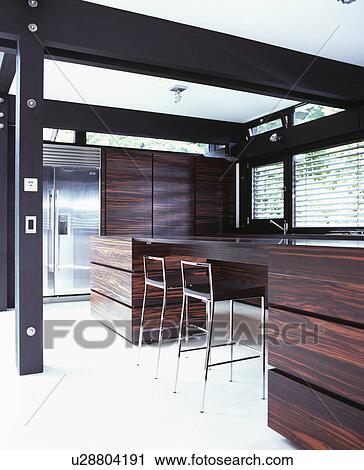 Dark wood fitted units in large modern kitchen View Large Photo Image Stock Image - Dark wood fitted units in large modern kitchen. Fotosearch