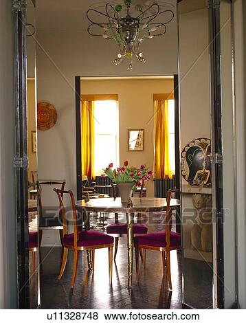 Stock Photo - Double doors open to antique table and chairs in traditional dining room with polished parquet floor. Fotosearch