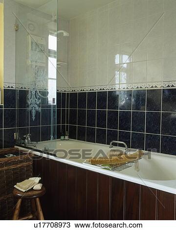 Engraved glass shower-screen on bath in black and white tiled traditional bathroom View Large Photo Image Stock Image - Engraved glass shower-screen on bath in black and white tiled traditional bathroom. Fotosearch