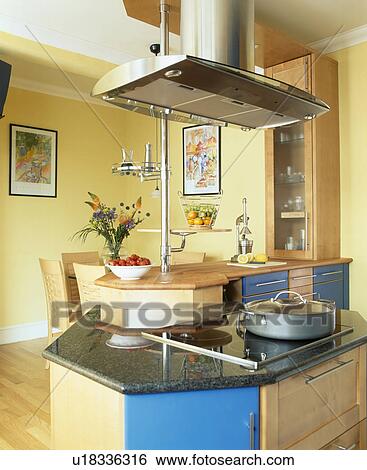 Stock Photograph - Extractor above hob in yellow kitchen. Fotosearch