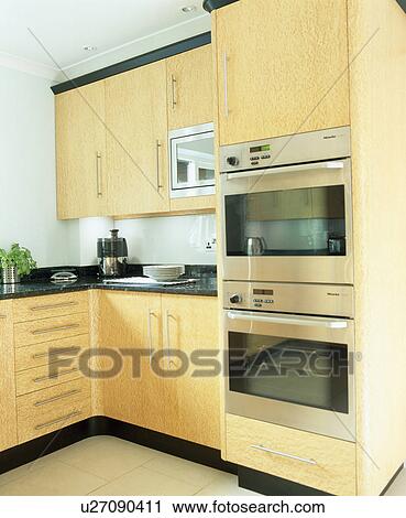 Eye-level double oven in modern kitchen with pale wood unit View Large Photo Image Stock Image - Eye-level double oven in modern kitchen with pale wood unit. Fotosearch