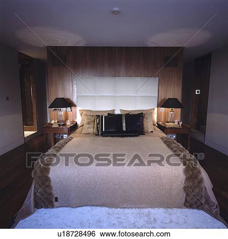 Faux fur throw and padded headboard on bed in modern townhouse bedroom View Large Photo Image Stock Photograph - Faux fur throw and padded headboard on bed in modern townhouse bedroom. Fotosearch