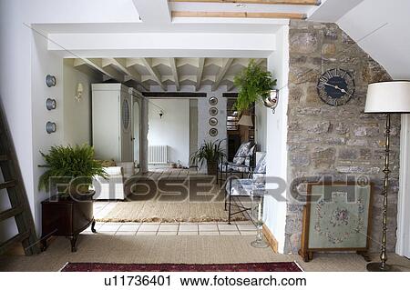 Firescreen and lamp in front of exposed stone wall in modern cottage hall extension with sisal carpet View Large Photo Image Stock Image - Firescreen and lamp in front of exposed stone wall in modern cottage hall extension with sisal carpet. Fotosearch