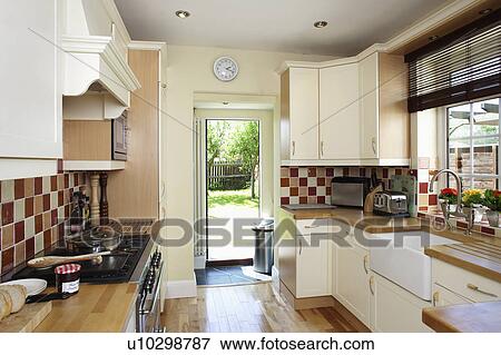 Stock Photo - Fitted cream cupboards and units in traditional kitchen. Fotosearch