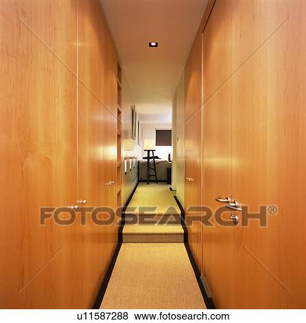 Fitted cupboards on either side of narrow modern landing View Large Photo Image Stock Photo - Fitted cupboards on either side of narrow modern landing. Fotosearch
