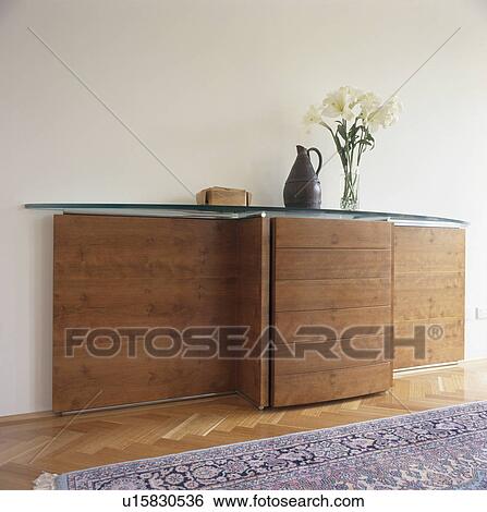 Stock Photograph - Fitted glass-topped table in modern white hall. Fotosearch