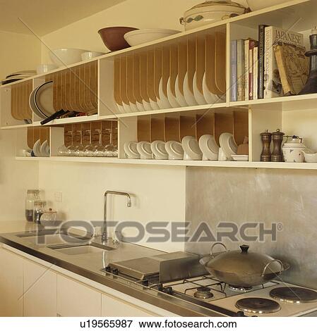 Stock Photo - Fitted plate rack above sink in modern kitchen. Fotosearch