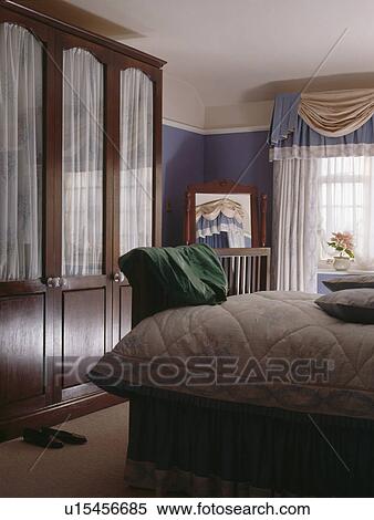 Fitted wardrobe with internal drapes in blue bedroom View Large Photo Image Stock Photography - Fitted wardrobe with internal drapes in blue bedroom. Fotosearch
