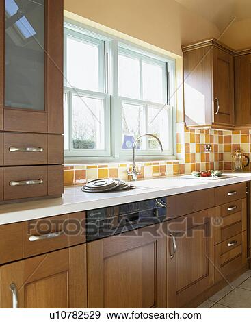 Stock Photo - Fitted wooden units in traditional terracotta kitchen. Fotosearch