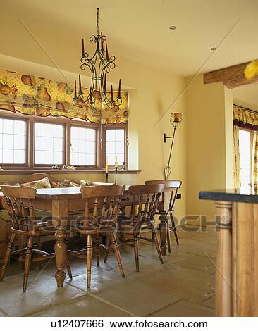 Stock Photograph - Flagstoned floor and wooden table and chairs in neutral dining room. Fotosearch
