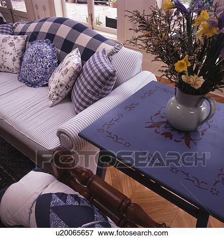 Floral painted blue table beside white sofa with blue checked and floral cushions View Large Photo Image Stock Photo - Floral painted blue table beside white sofa with blue checked and floral cushions. Fotosearch