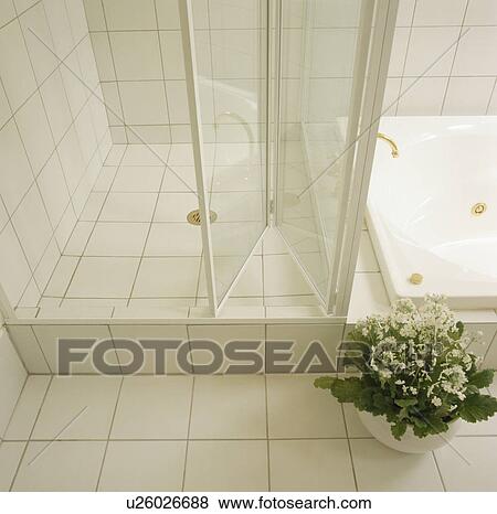 Stock Photo - Folding glass doors on white tiled shower. Fotosearch
