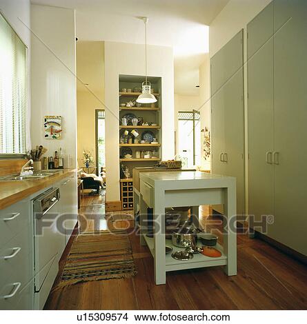 Food preparation table in modern kitchen with large fitted cupboard View Large Photo Image Picture - Food preparation table in modern kitchen with large fitted cupboard. Fotosearch