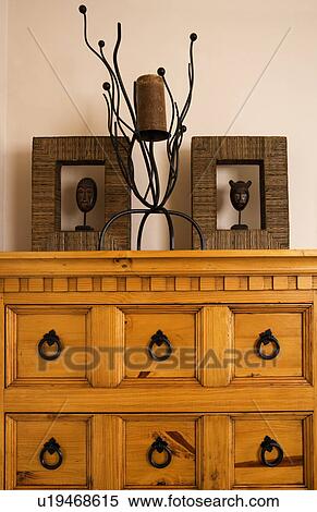 Stock Photography - Framed sculpture and modern candlestick on pine merchants chest. Fotosearch