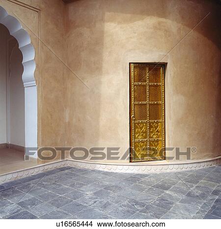 Picture - Gilt door in sandstone wall in Indian courtyard with marble paving. Fotosearch