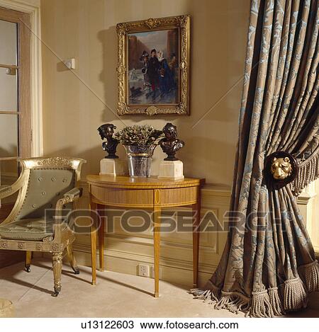 Gilt-framed picture above console table with bronze busts and gilt-framed chair in living room with damask curtains View Large Photo Image Stock Image - Gilt-framed picture above console table with bronze busts and gilt-framed chair in living room with damask curtains. Fotosearch
