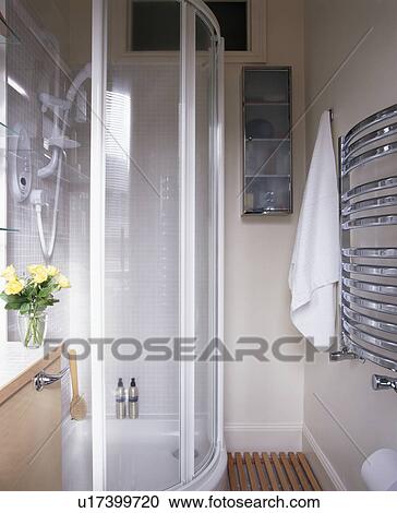 Stock Image - Glass shower cabinet in small modern white bathroom. Fotosearch