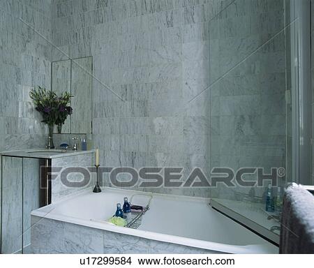 Picture - Glass shower door on bath in modern marble tiled bathroom. Fotosearch