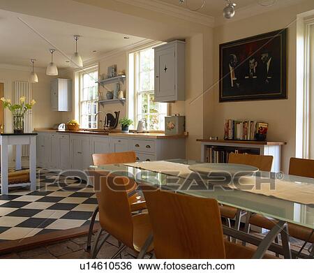 Stock Photograph - Glass table and modern chairs in country kitchen dining room extension with Marmoleum flooring. Fotosearch