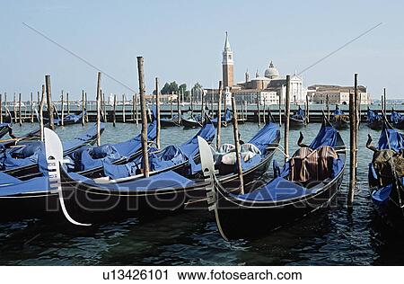 Stock Image - Gondolas with blue covers moored on the Grand Canal in Venice with view of San Giorgio Maggiore in the background&#10;. Fotosearch