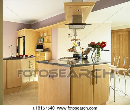 Stock Image - Granite worktop on island unit in modern country kitchen. Fotosearch