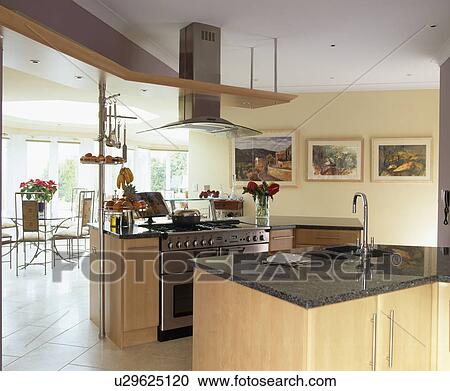 Stock Image - Granite worktop on island unit in modern country kitchen. Fotosearch
