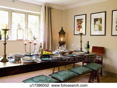 Green cushions on oak bench with oak table in neutral dining room with lighted lantern in corner of the room View Large Photo Image Stock Image - Green cushions on oak bench with oak table in neutral dining room with lighted lantern in corner of the room. Fotosearch