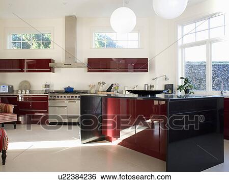 Stock Photograph - Island unit in large modern country kitchen with cream tiled floor. Fotosearch