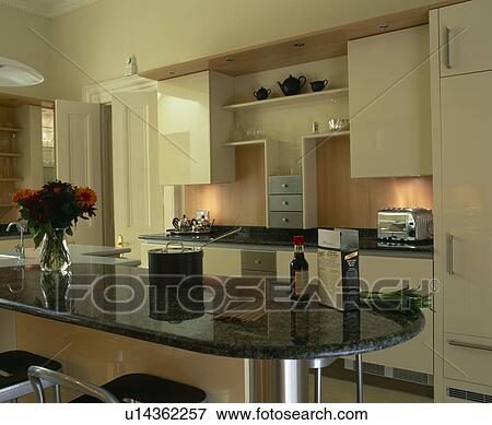 Stock Photo - Island unit with granite worktop in modern cream kitchen. Fotosearch