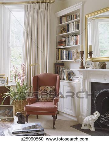 Kelim Cushion On Red Armchair Beside Fireplace In Living Room With