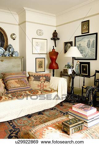 Kelim cushions and cream throw on sofa in living room with tailor's dummy in corner of room View Large Photo Image Stock Photo - Kelim cushions and cream throw on sofa in living room with tailor's dummy in corner of room. Fotosearch