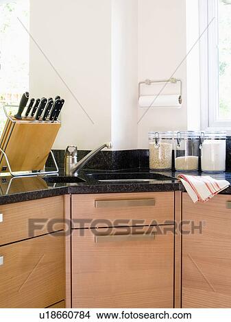 Picture - Knife-block on granite worktop beside corner sink in modern kitchen. Fotosearch