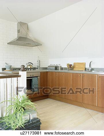 Stock Image - Laminate wood flooring in modern kitchen with fitted wooden units. Fotosearch