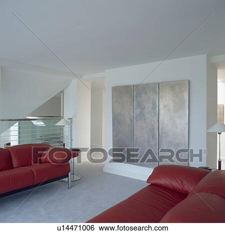 Large abstract triptych painting in modern city living room with red sofas View Large Photo Image Stock Photograph - Large abstract triptych painting in modern city living room with red sofas. Fotosearch