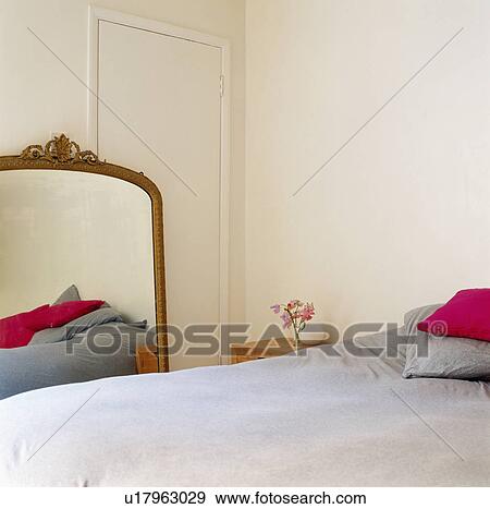 Large antique mirror on floor beside bed with grey bedlinen in modern white bedroom View Large Photo Image Stock Photo - Large antique mirror on floor beside bed with grey bedlinen in modern white bedroom. Fotosearch
