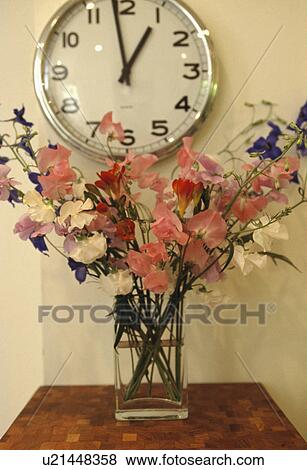 Large circular clock above pink sweet peas in glass vase View Large Photo Image Stock Photo - Large circular clock above pink sweet peas in glass vase. Fotosearch
