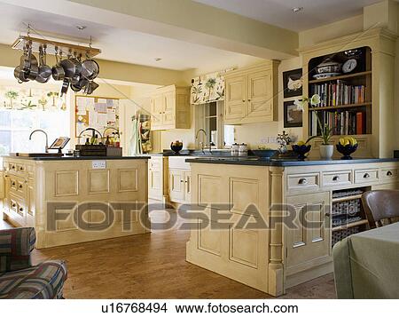 Picture - Large country kitchen with cream painted fitted units. Fotosearch