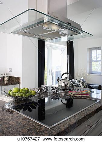 Large glass and steel extractor above halogen hob in modern kitchen View Large Photo Image Stock Photo - Large glass and steel extractor above halogen hob in modern kitchen. Fotosearch