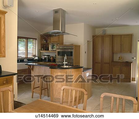 Stock Photo - Large modern kitchen dining room with pale wood units. Fotosearch