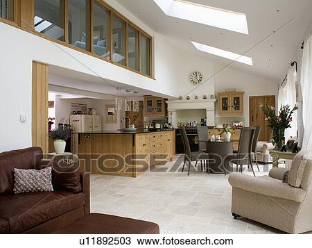 Large modern open-plan kitchen dining room extension with comfortable armchair and sofa View Large Photo Image Stock Image - Large modern open-plan kitchen dining room extension with comfortable armchair and sofa. Fotosearch