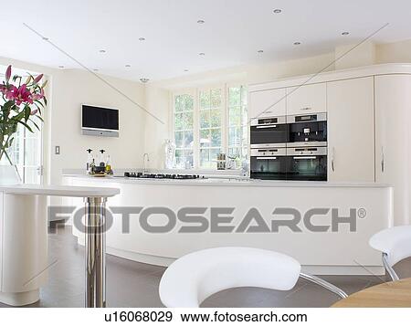 Stock Photo - Large modern white country kitchen with curved island unit. Fotosearch