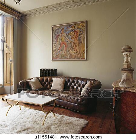 Large Picture Above Brown Leather Chesterfield Sofa In Living Room