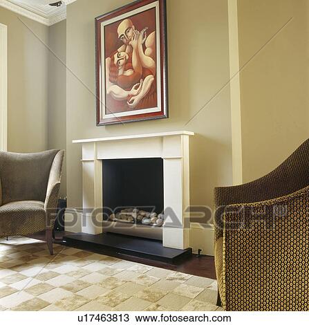 large picture above cream fireplace in beige living room with brown velvet armchairs and cream textured patchwork rug View Large Photo Image Stock Image - large picture above cream fireplace in beige living room with brown velvet armchairs and cream textured patchwork rug. Fotosearch