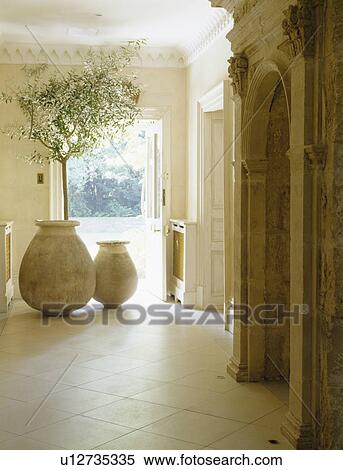 Stock Photography - Large pithoi pots beside front door in cream country hall. Fotosearch