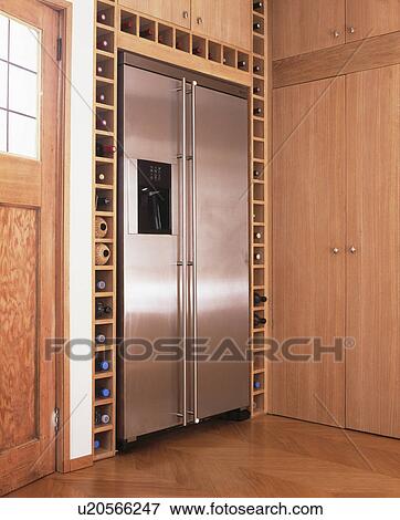 Stock Photo - Large stainless steel American-style freezer in modern kitchen with fitted wine storage. Fotosearch