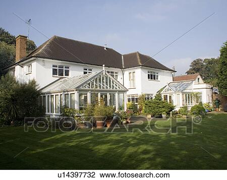 Stock Image - Large white thirties house with conservatory extension. Fotosearch