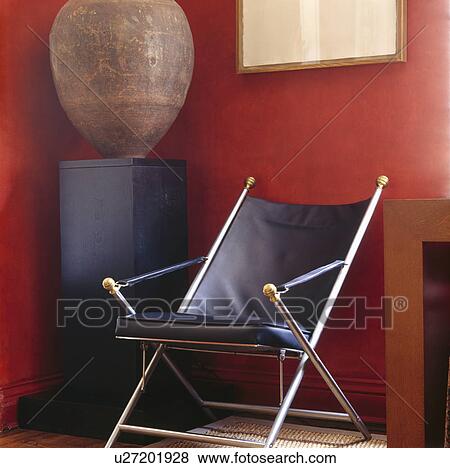 Leather and chrome chair beside plinth with large amphora pot in corner of red living room View Large Photo Image Stock Photo - Leather and chrome chair beside plinth with large amphora pot in corner of red living room. Fotosearch