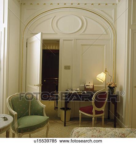Lighted lamp on desk beside open door in hotel bedroom View Large Photo Image Stock Photography - Lighted lamp on desk beside open door in hotel bedroom. Fotosearch