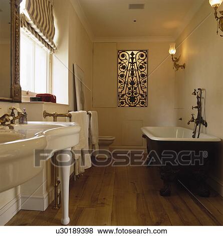 Stock Photo - Lighting behind decorative metal grille in white bathroom with wooden flooring. Fotosearch
